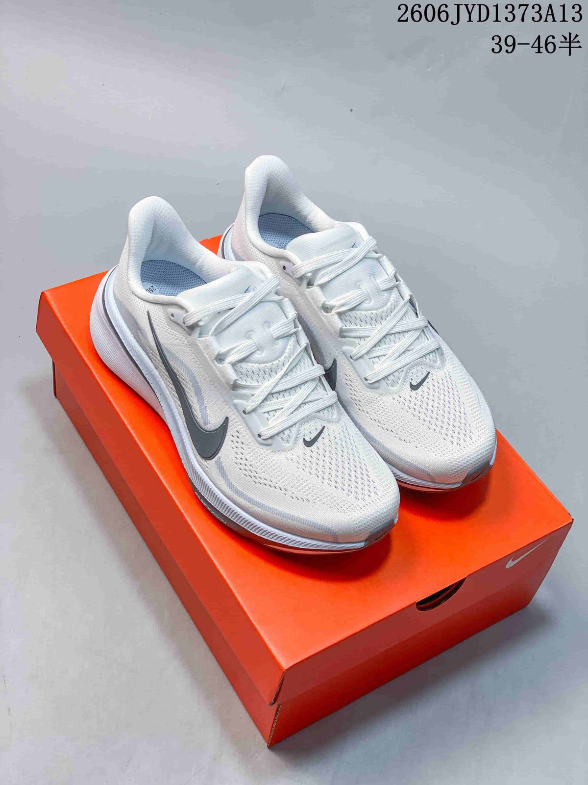 Pair of white Nike Pegasus 42 running shoes with gray accents on an orange shoebox