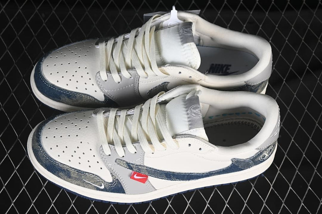 Pair of white and grey low-top sneakers with dark blue patterned overlays, white laces, and red side tabs.
