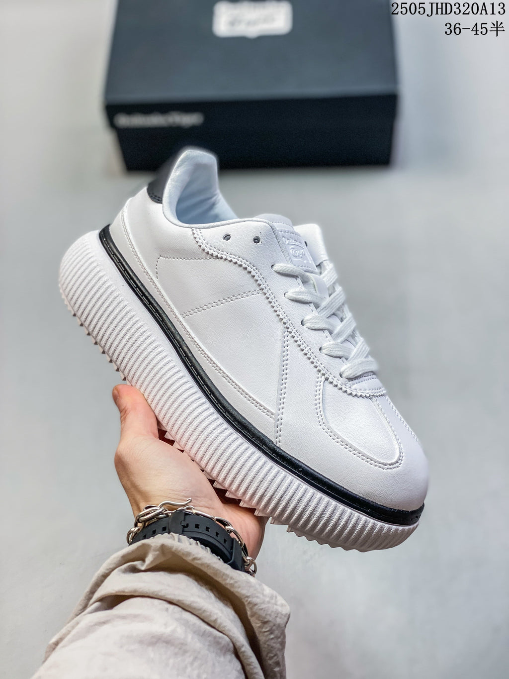 Angled side view of the white sneaker with a ribbed sole and black accent.