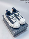 White and navy low-top lace-up sneakers on a branded box