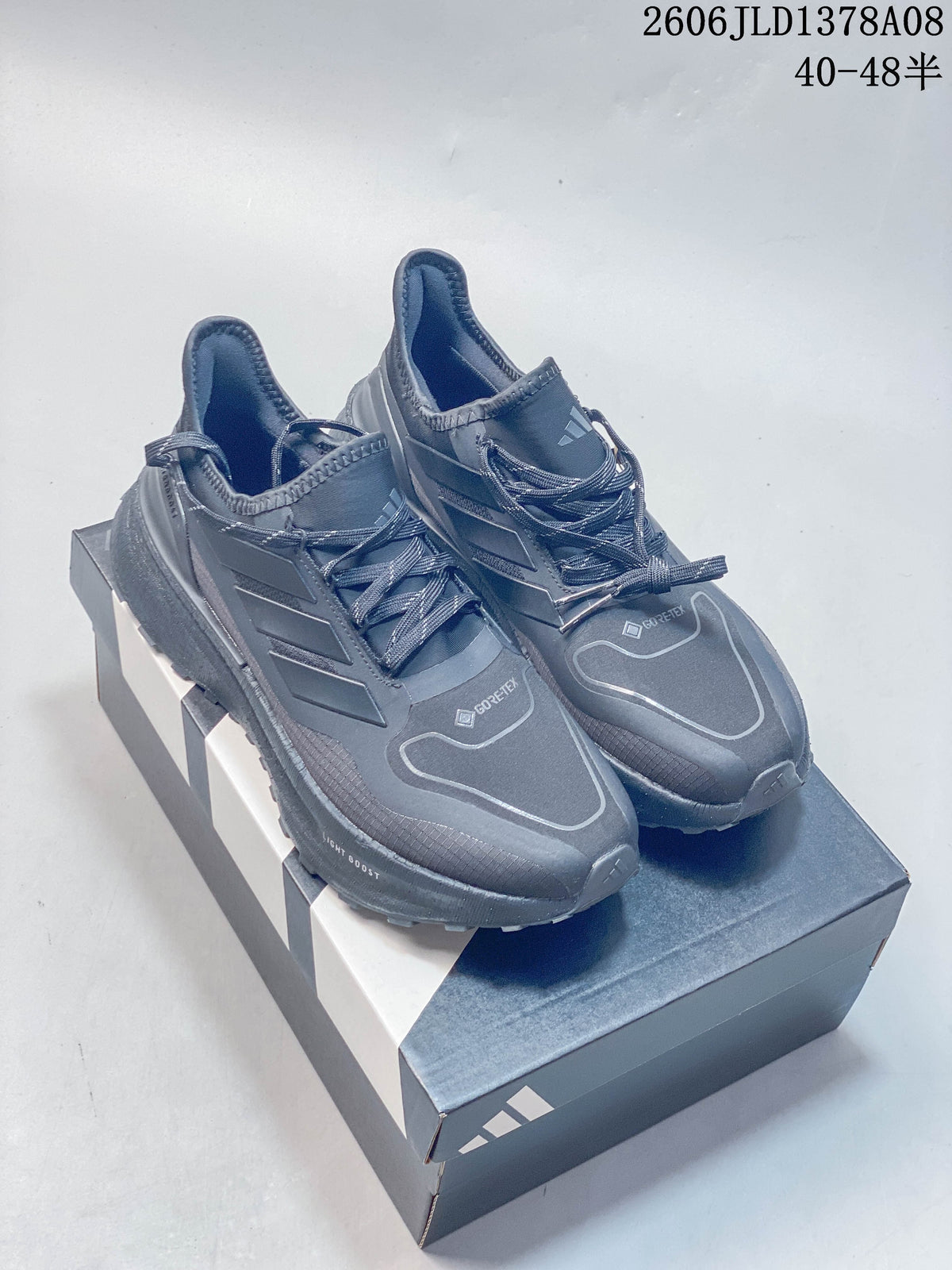 Pair of grey Adidas Ultraboost 5 Climawarm shoes on a shoebox