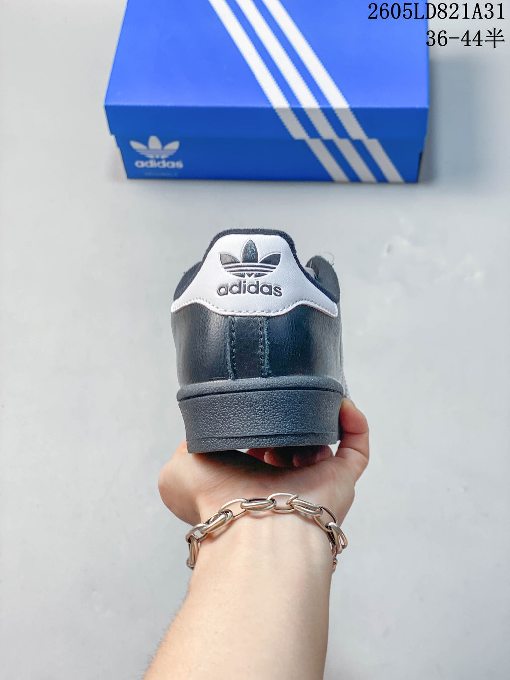 Rear view showing the heel details and dark sole of an Adidas Superstar sneaker.