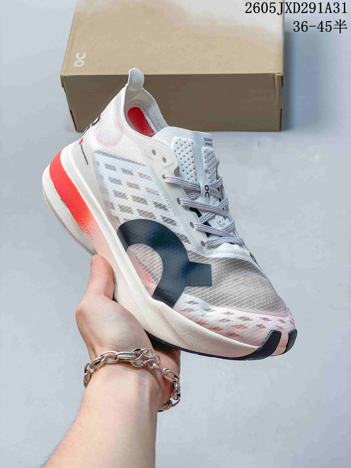 Angled side view of the white and gray shoe with navy and coral accents