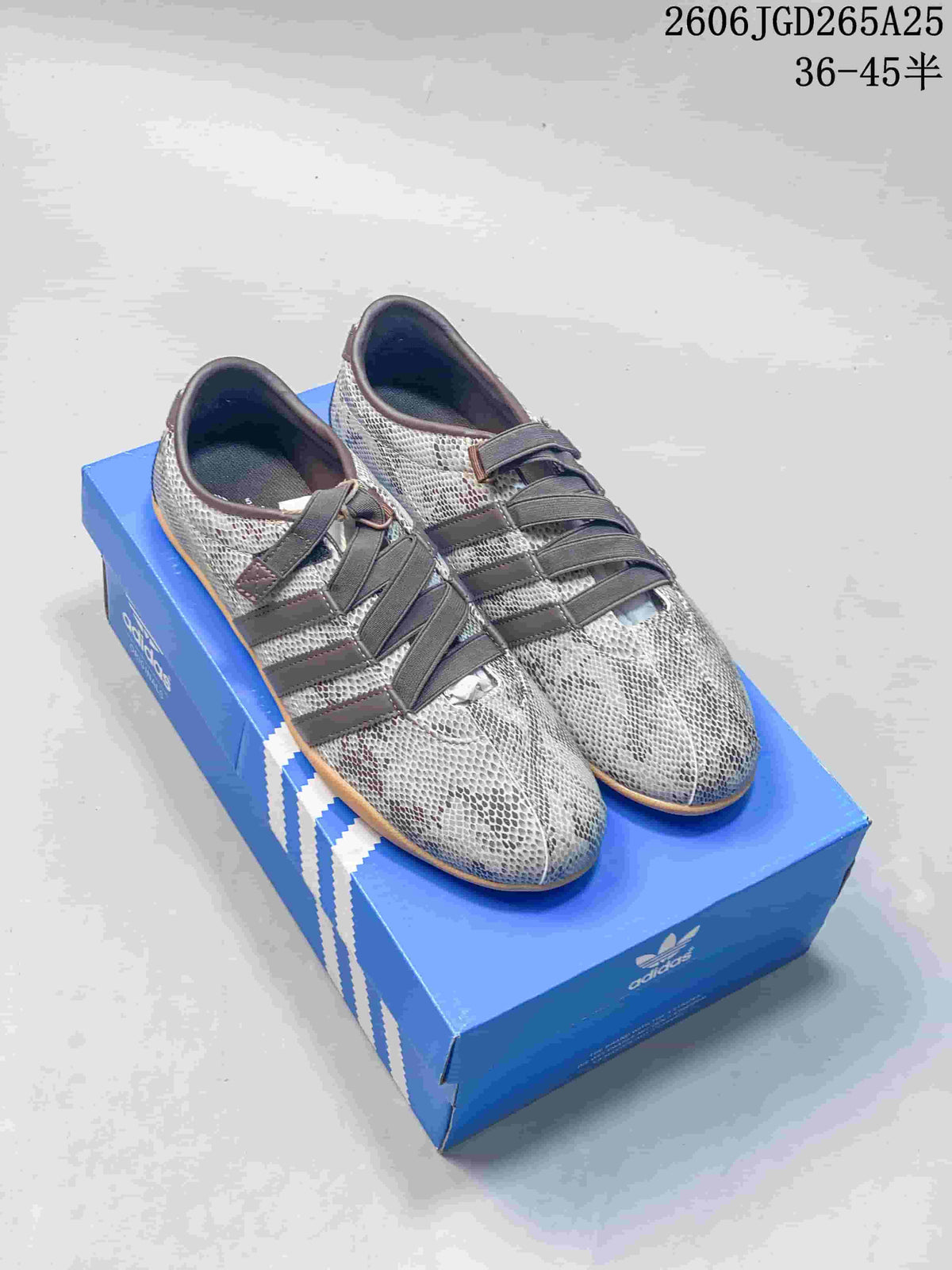 Pair of gray snakeskin-style print Adidas Tokyo W sneakers with dark stripes and gum-colored outsoles.
