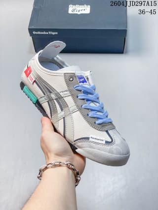 Onitsuka Tiger Mexico 66 sneaker in a gray colorway with blue laces and blue-green outsole accents.