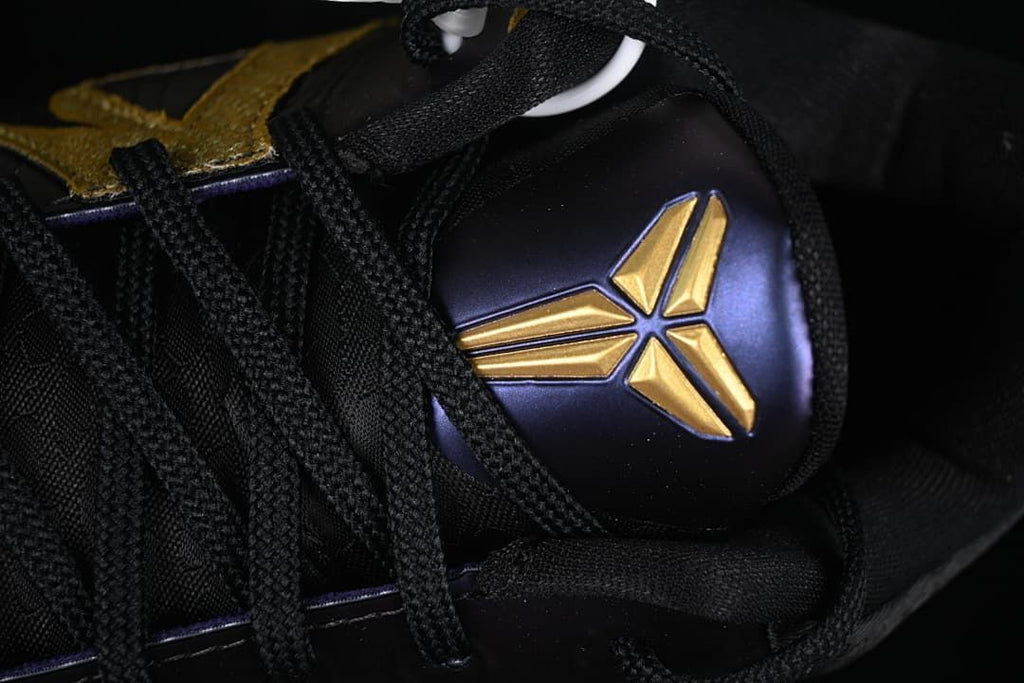Close-up of the black laces and gold Kobe logo on the purple tongue