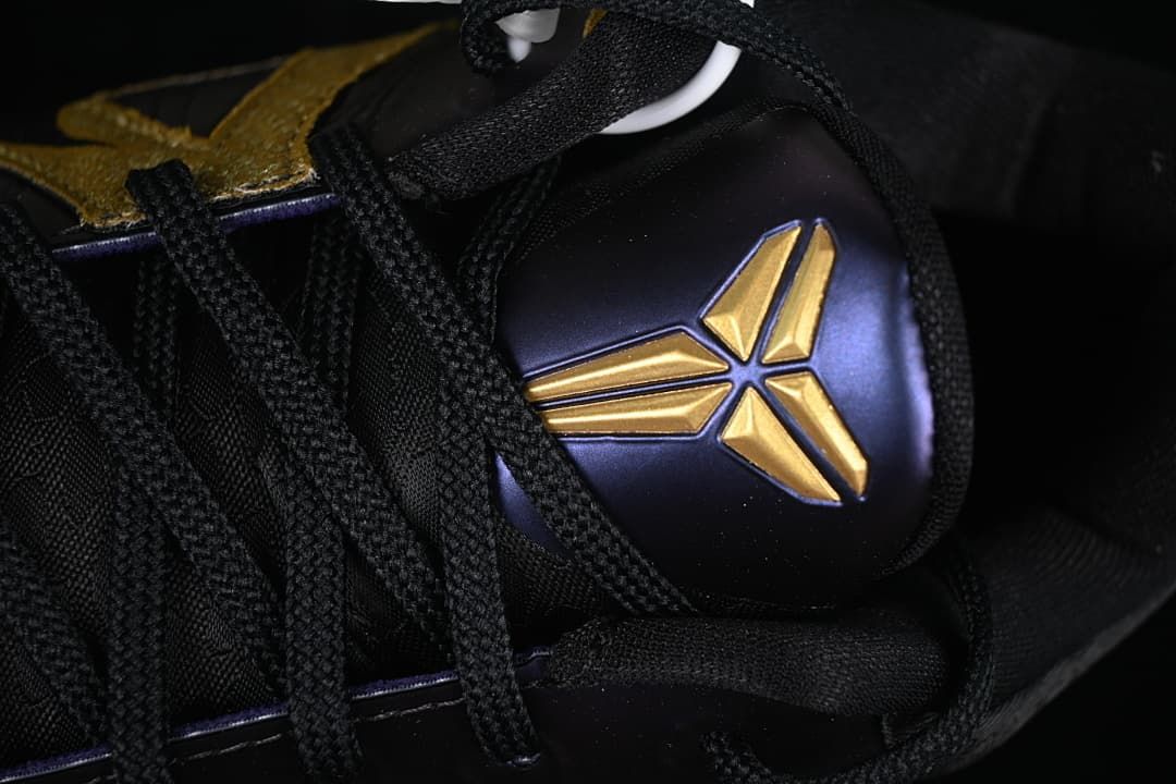 Close-up of the black laces and gold Kobe logo on the purple tongue