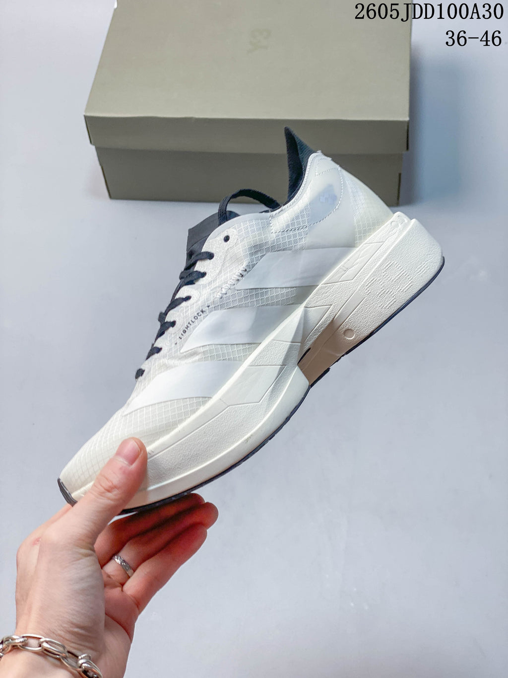 Side view of the white running shoe with dark graphic accents