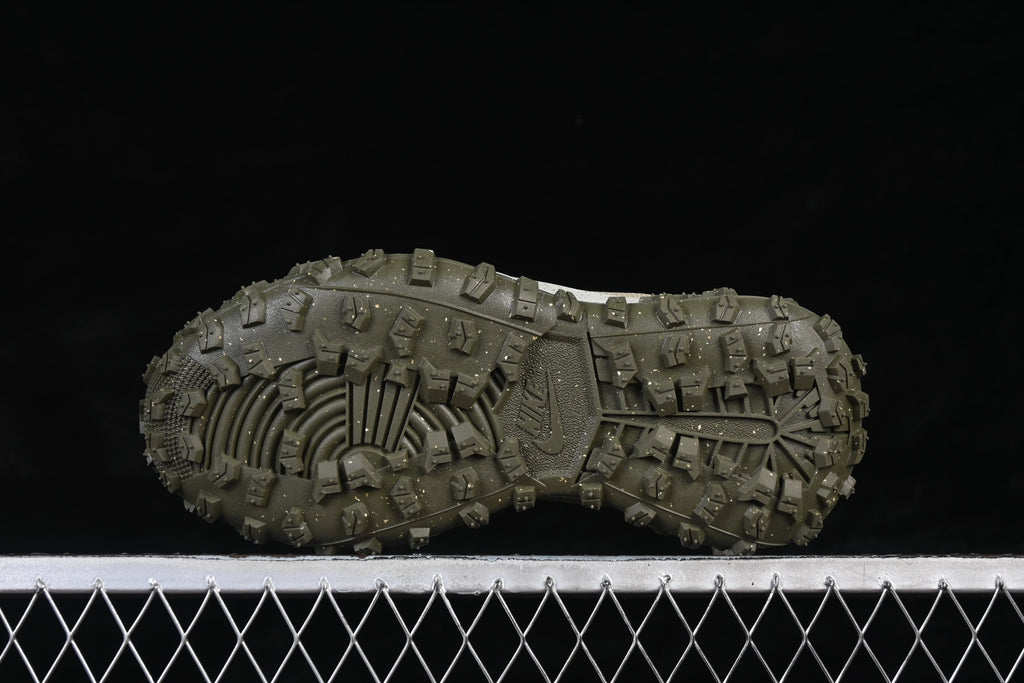 Underside view of the olive outsole with deep, raised lugs.
