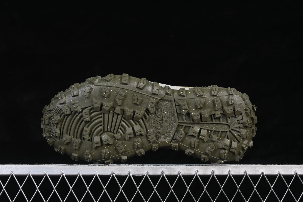 Underside view of the olive outsole with deep, raised lugs.