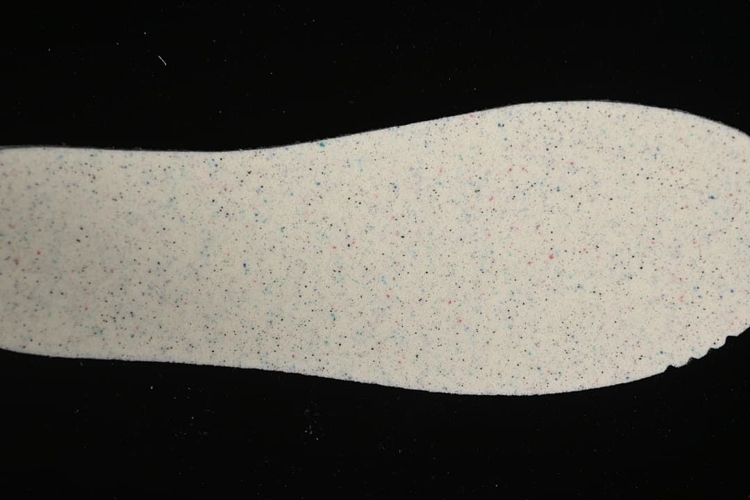 Close-up of a light-colored shoe component with multicolored speckles