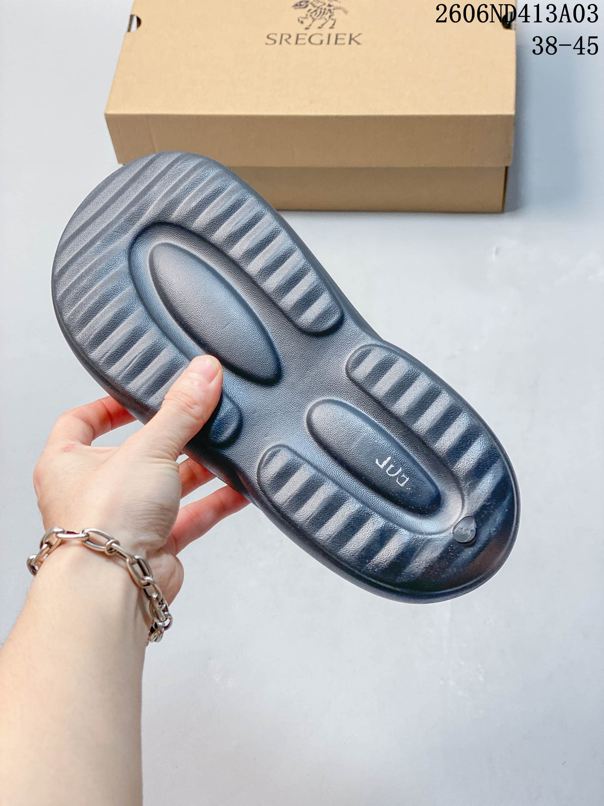 Underside of a dark gray sandal sole with molded tread.