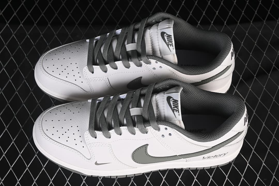 Pair of white and grey Nike SB Dunk Low sneakers shown from above.