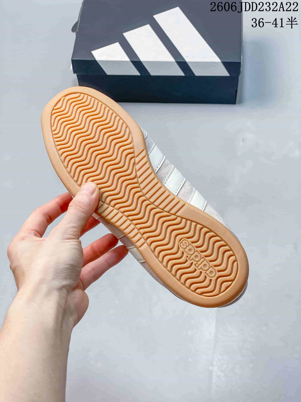 Underside of a shoe showing a gum-colored outsole with wavy tread