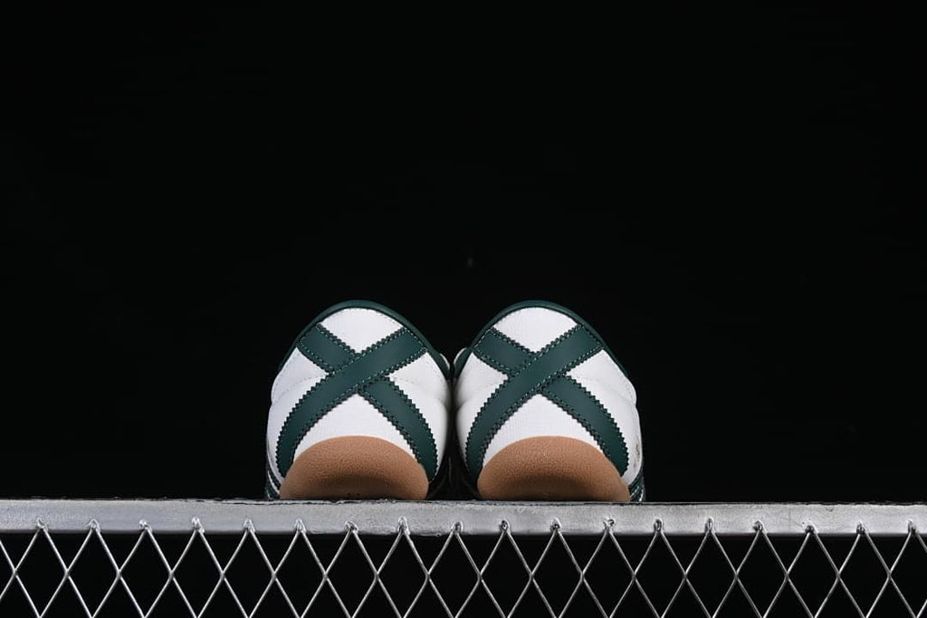 Rear view of the paired sneakers showing dark green heel stripes and gum soles