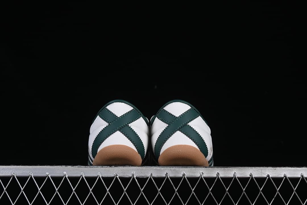 Rear view of the paired sneakers showing dark green heel stripes and gum soles