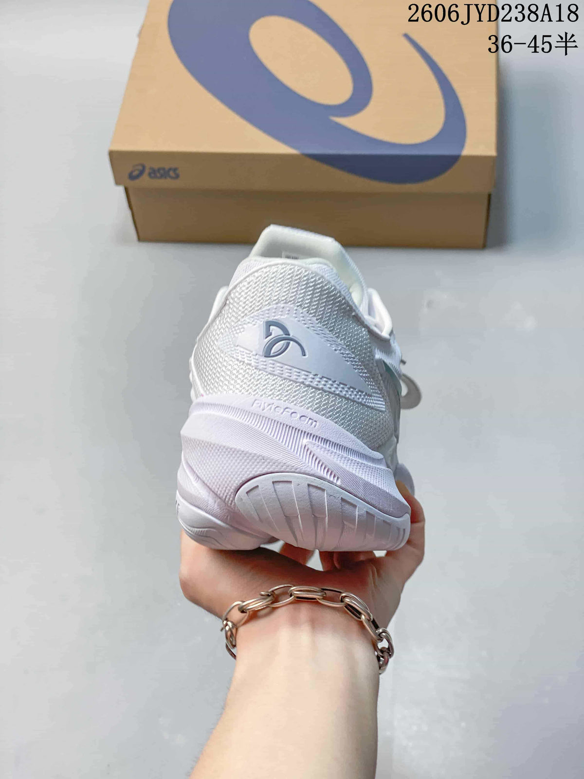 Rear view of the white tennis shoe showing the heel and sole