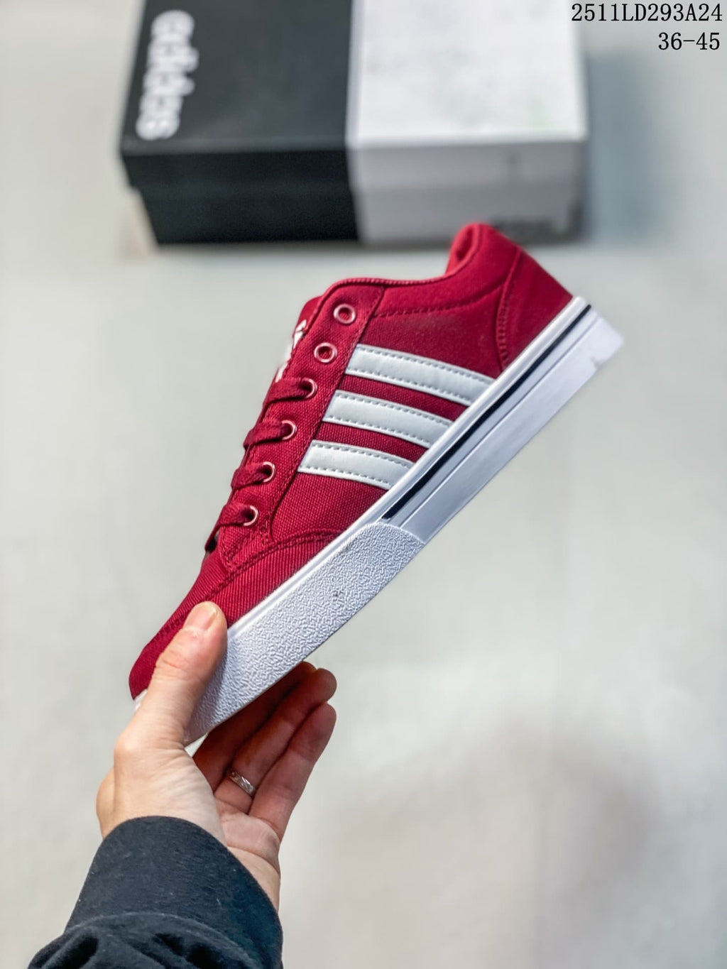 Side profile of a burgundy sneaker with three white stripes and a white sole