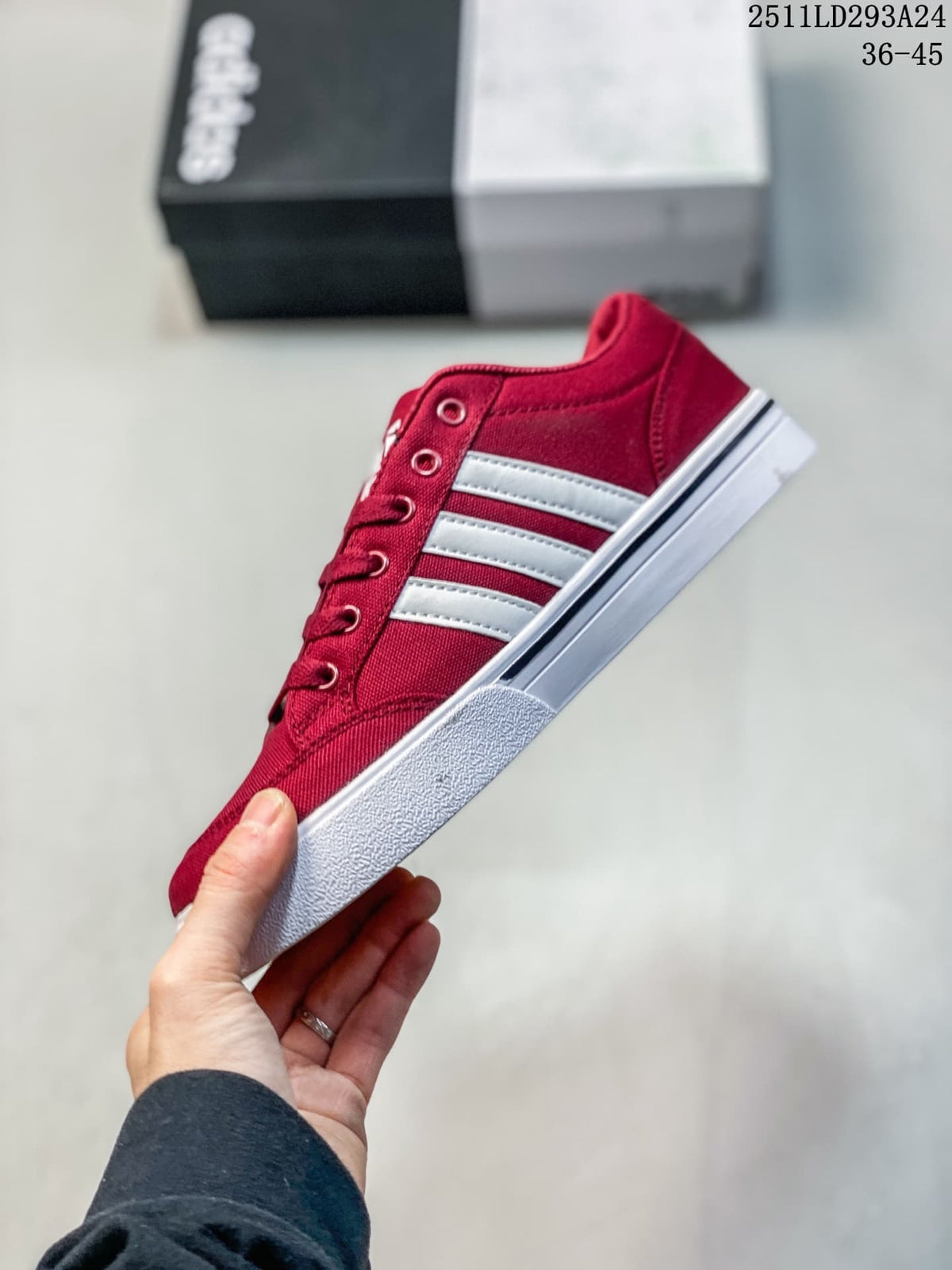 Side profile of a burgundy sneaker with three white stripes and a white sole