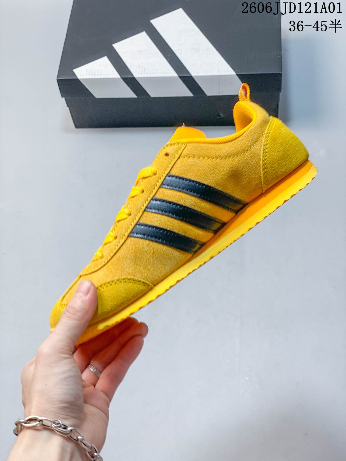 Side profile of the yellow sneaker with black stripes and a low-top shape