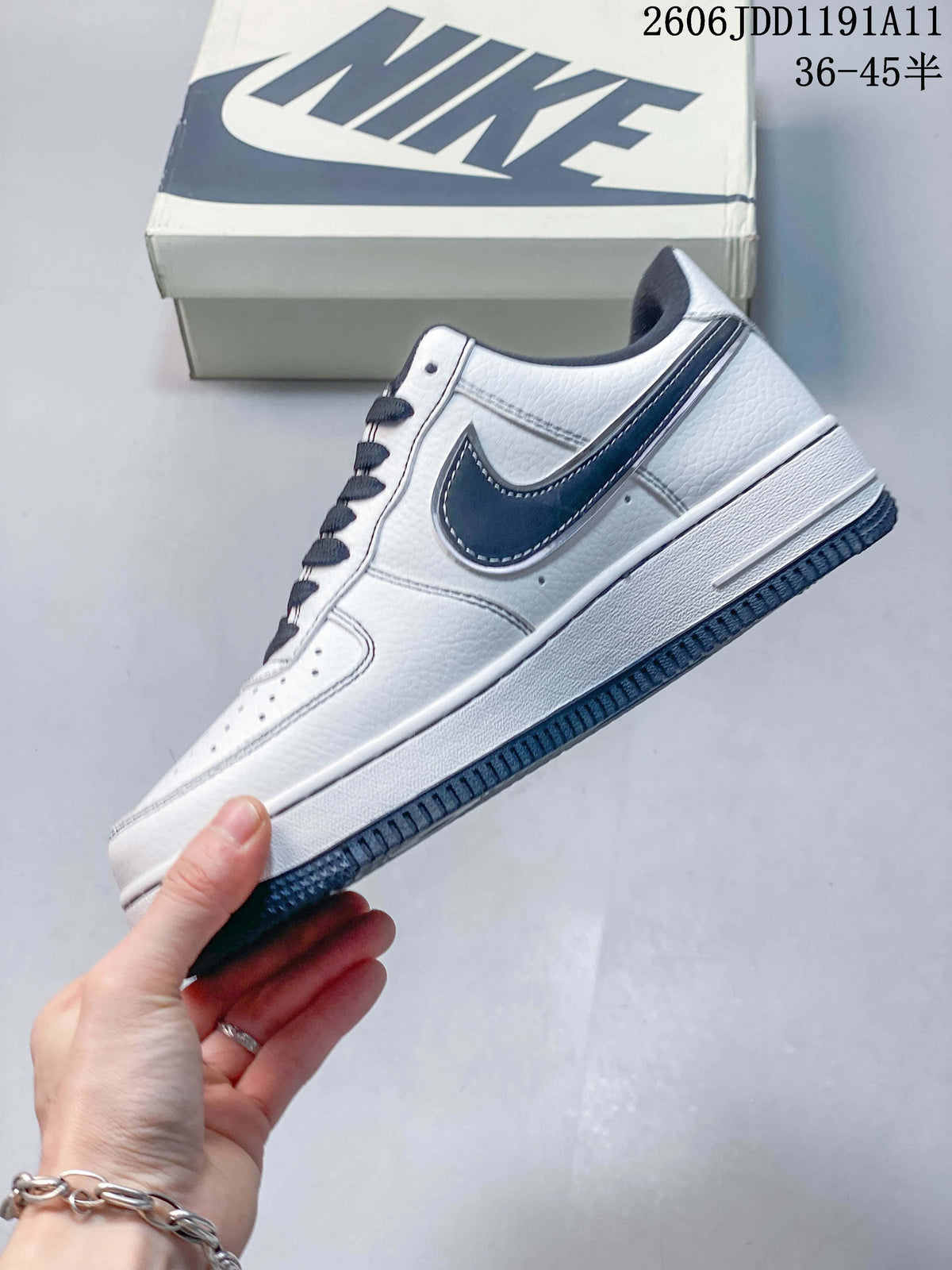 Side view showing the white upper, navy side detail, and navy outsole