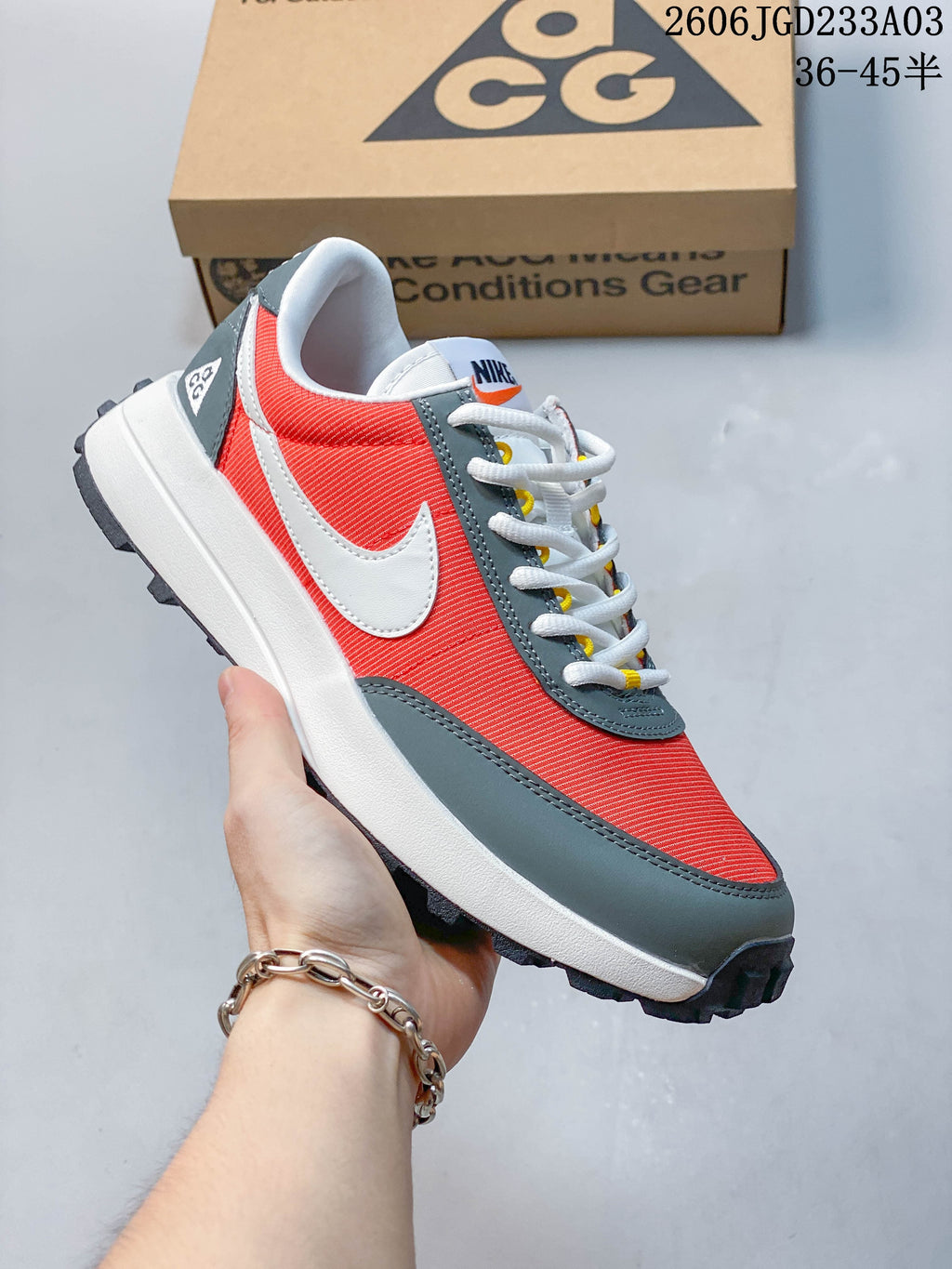 Angled side view of a coral-red, gray, and white Nike ACG LDV shoe