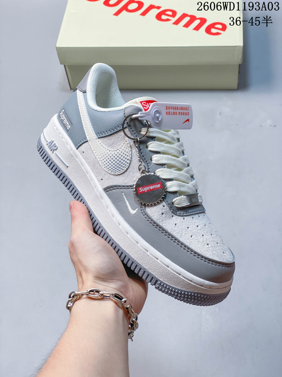 Angled side view of the grey and white sneakers with attached tag