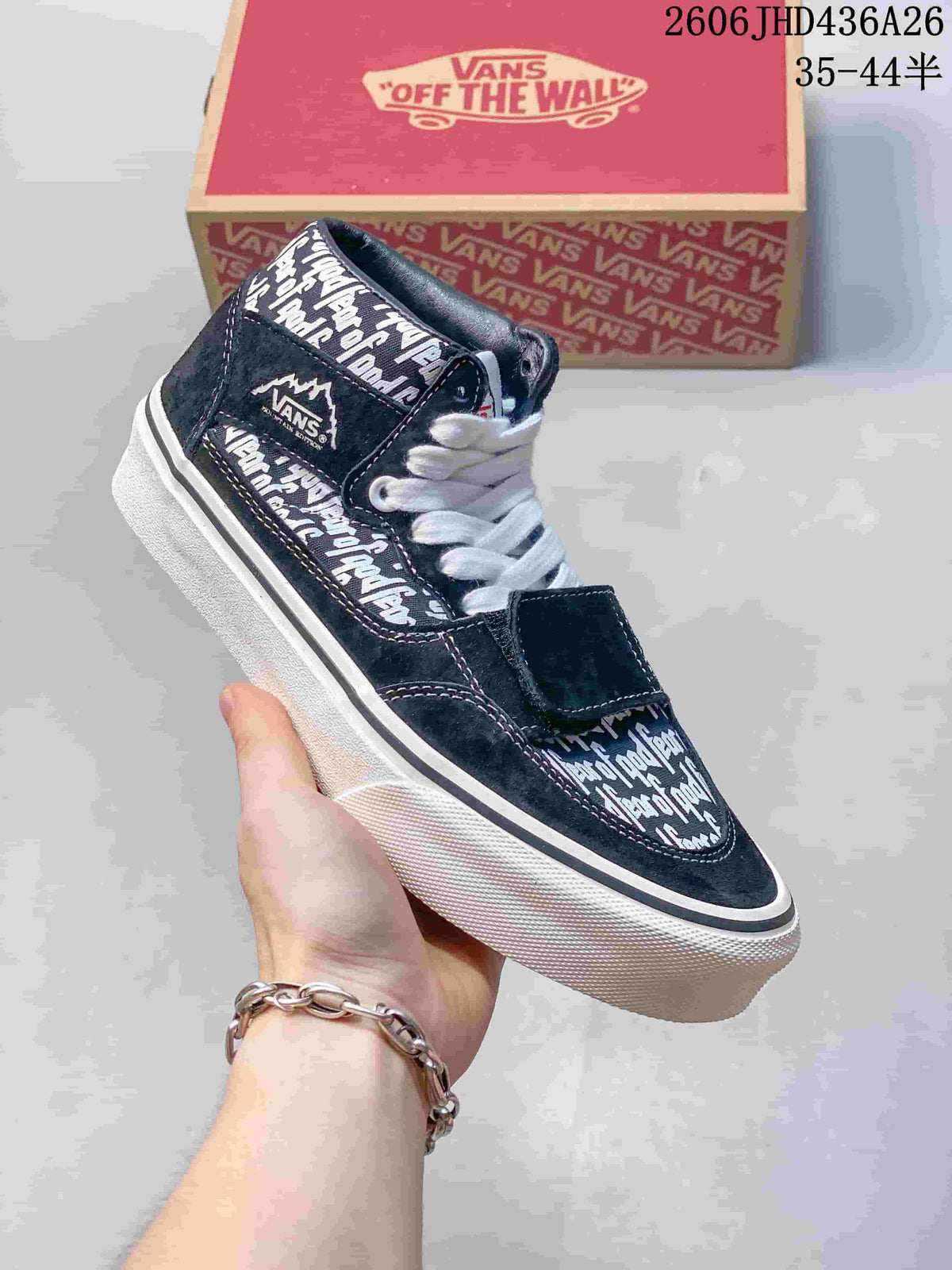 Side view of a navy printed Vans sneaker with white laces, an additional forefoot strap and a white sidewall.