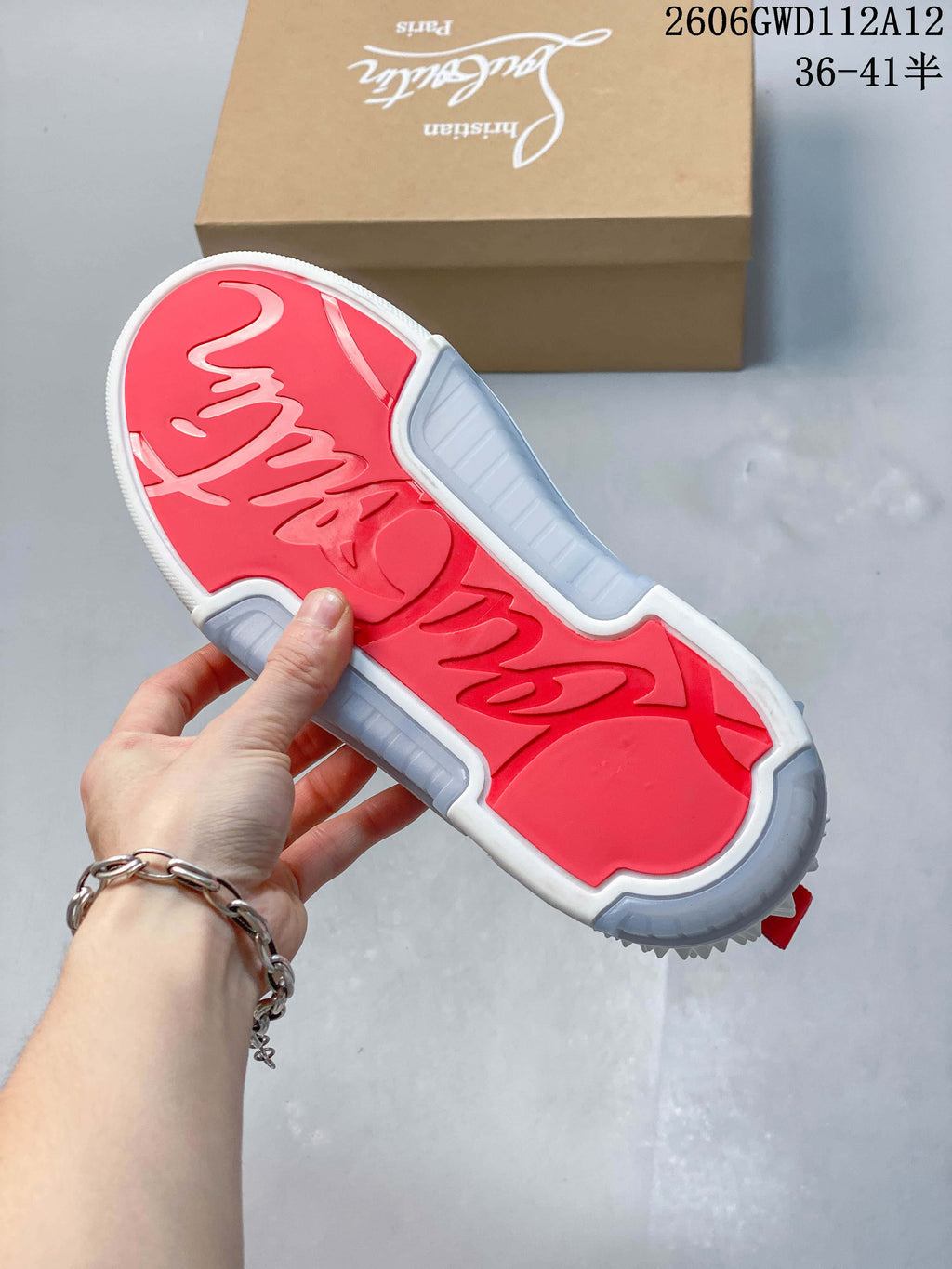 Underside of a sneaker showing a red and grey patterned outsole