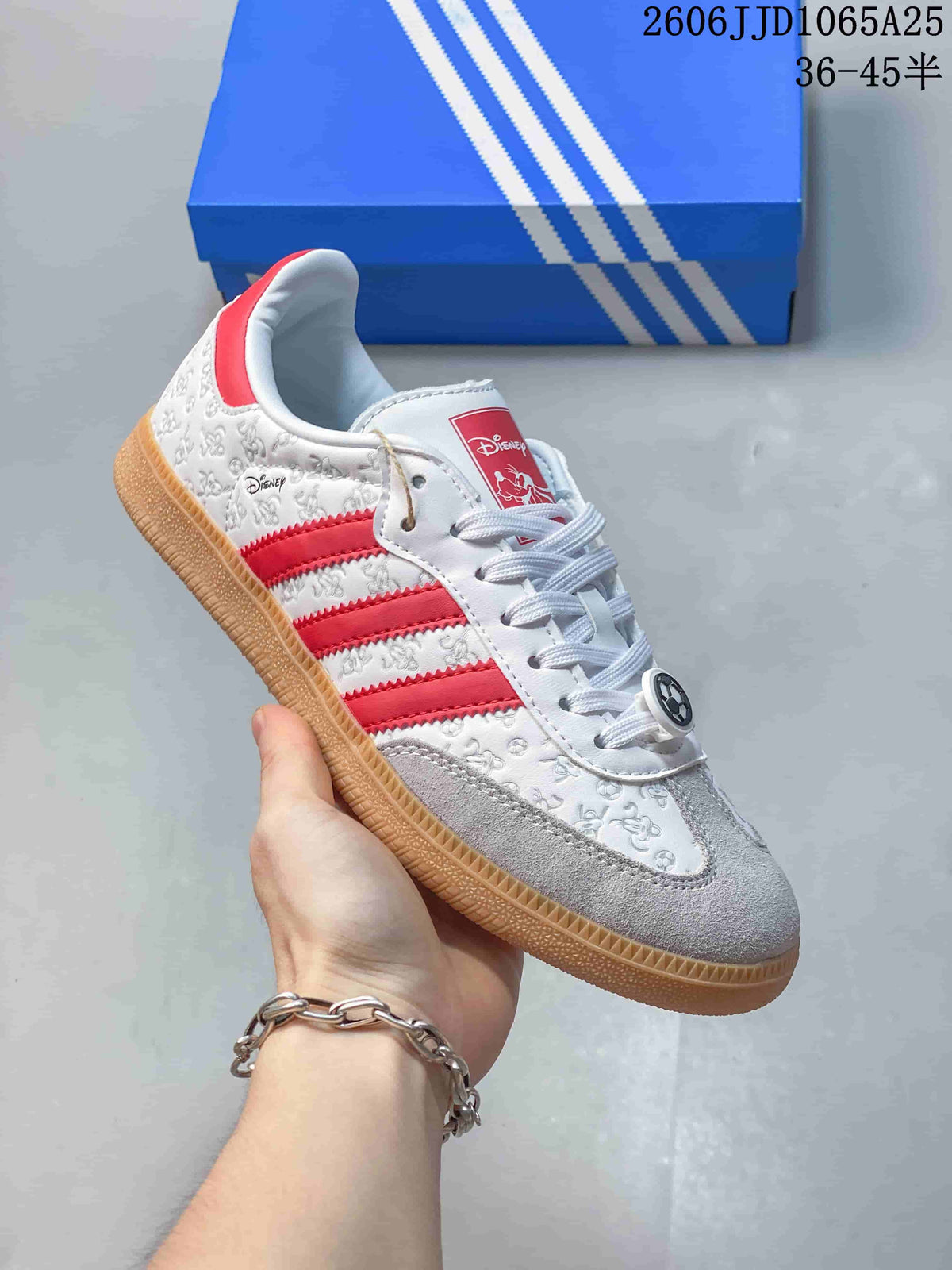 Side view of a white low-top sneaker with red stripes, character-themed details, and a gum-tone outsole