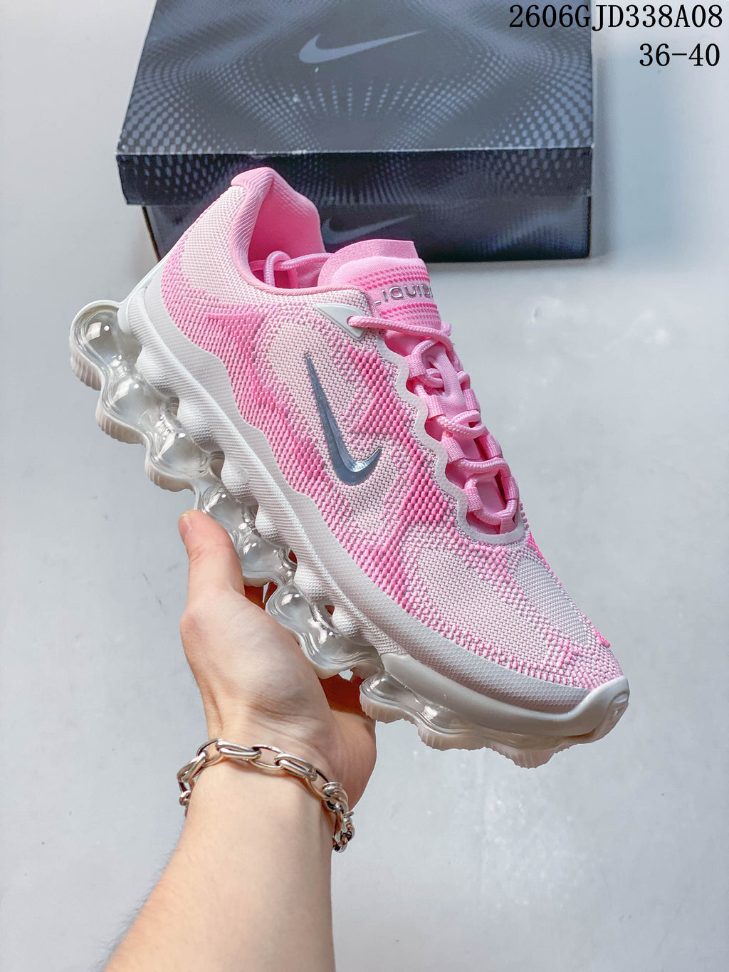 Side profile of the pink and light gray Nike Air Liquid Max sneaker.