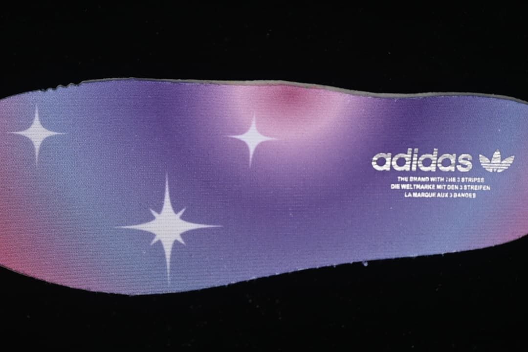 Close-up of a purple gradient insole with star graphics and adidas branding
