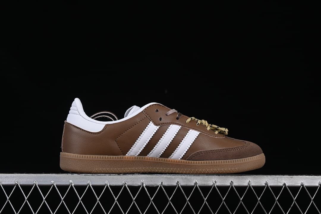 Side profile of a brown and white sneaker with three stripes and a gum-colored sole.