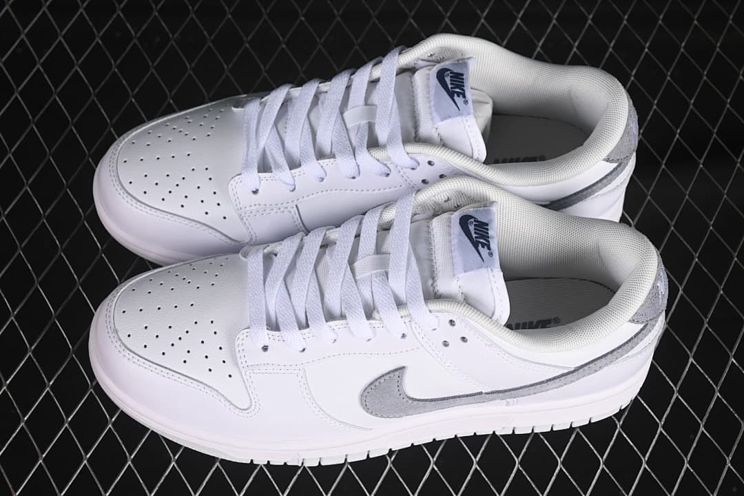 Pair of white and grey Nike SB Dunk Low sneakers