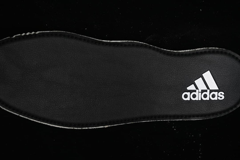 Black insole with a white Adidas logo.