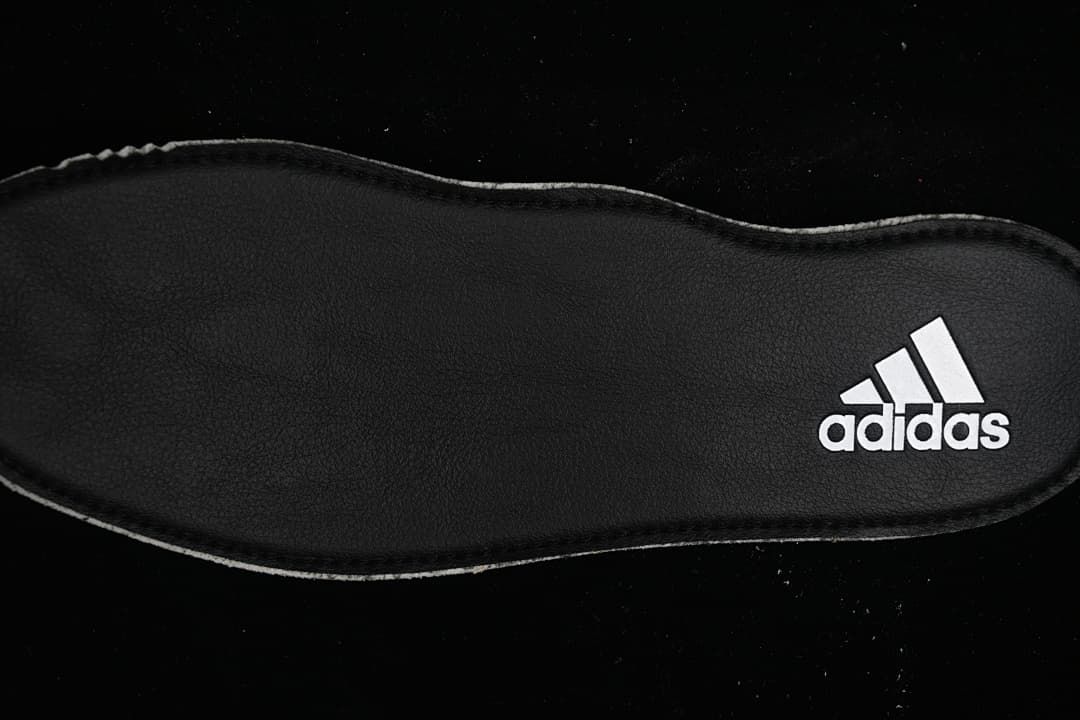 Black insole with a white Adidas logo.