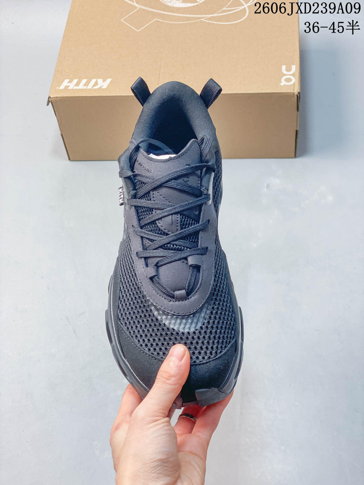 Front view of a charcoal lace-up shoe with an open-knit upper.