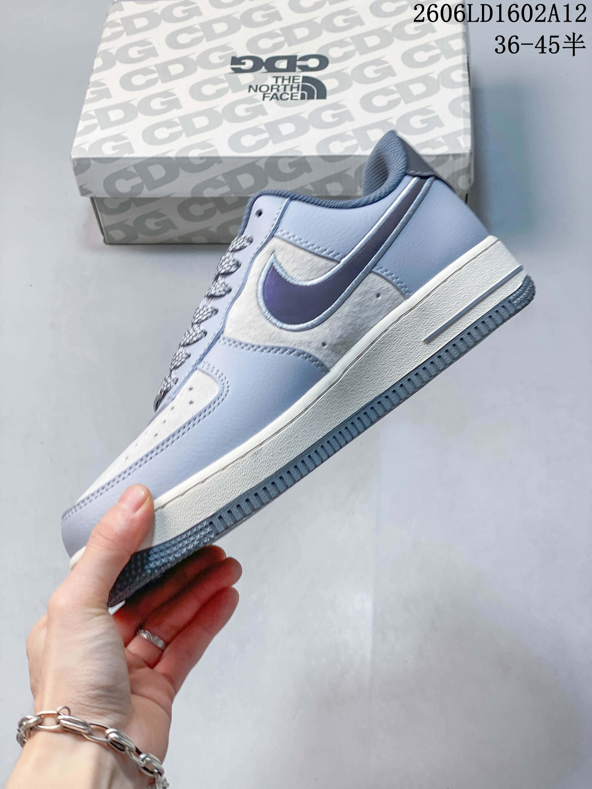 Side view of a pale grey low-top sneaker with off-white panels and a dark swoosh.