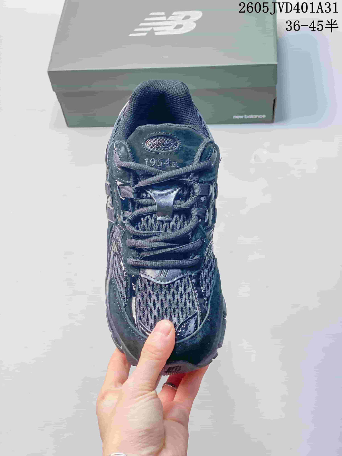 Top view of a charcoal gray New Balance sneaker with lace-up closure and 1954 tongue branding; size range text appears in the image.