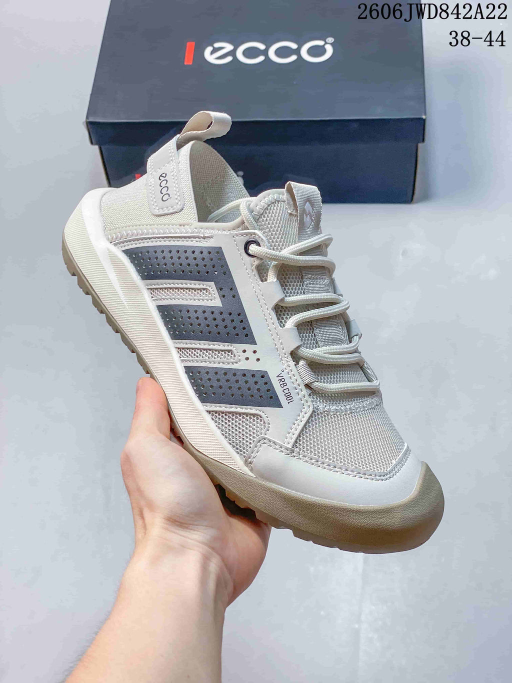 Angled side view of the light grey sneaker with dark side panels and heel pull tab.