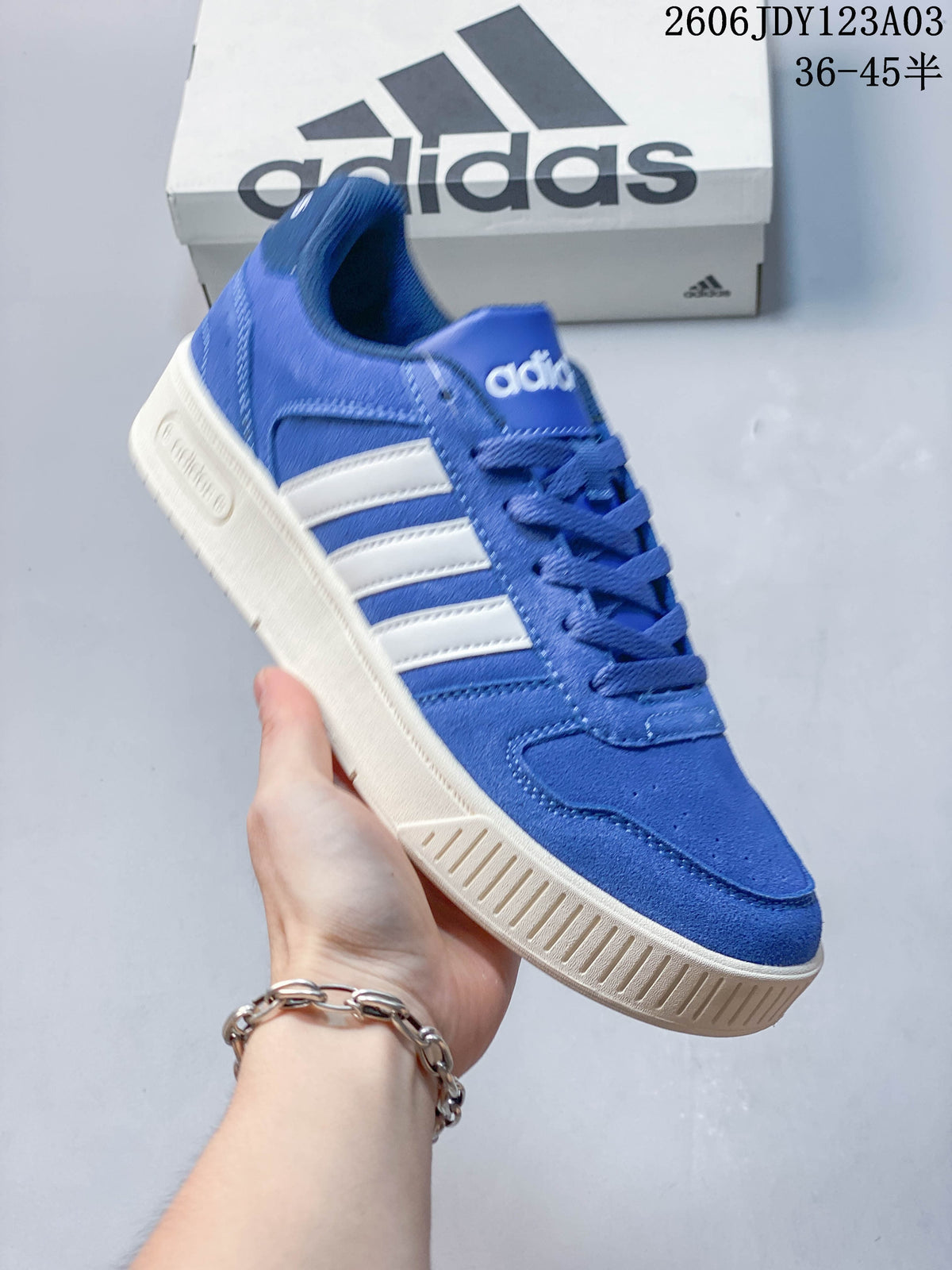 Blue Adidas low-top sneaker with light-colored side stripes and a contrasting ridged sole.