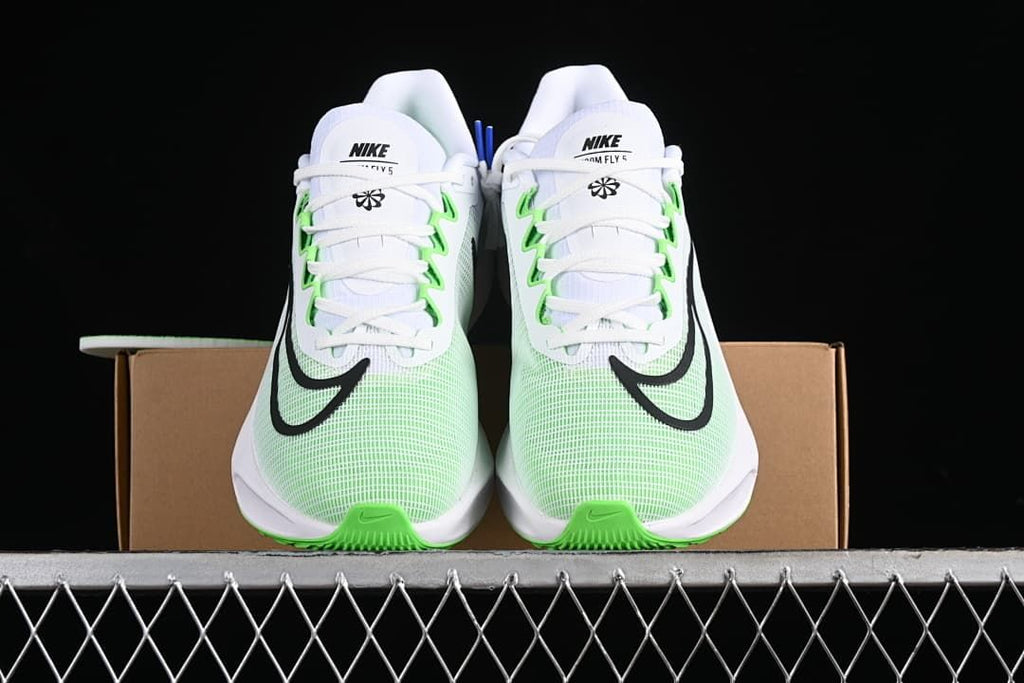 Front view of the pair showing white laces, green details, and black Swooshes