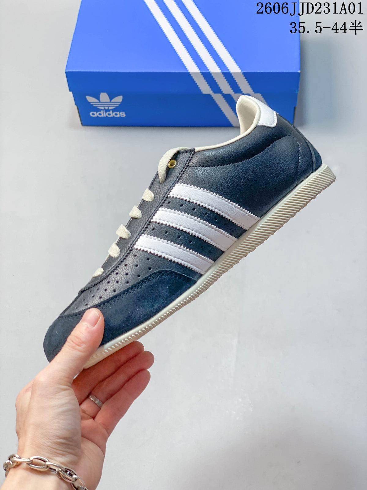 Side profile of the navy low-top sneaker with white stripes and perforated panels