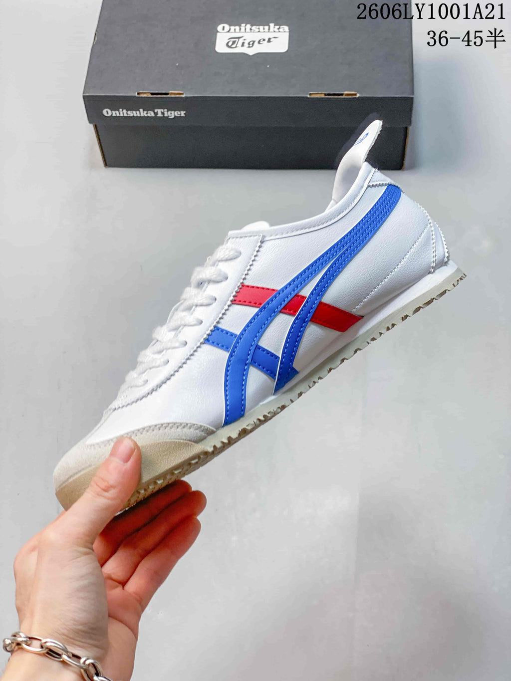 Side view of the white sneaker with blue and red stripes
