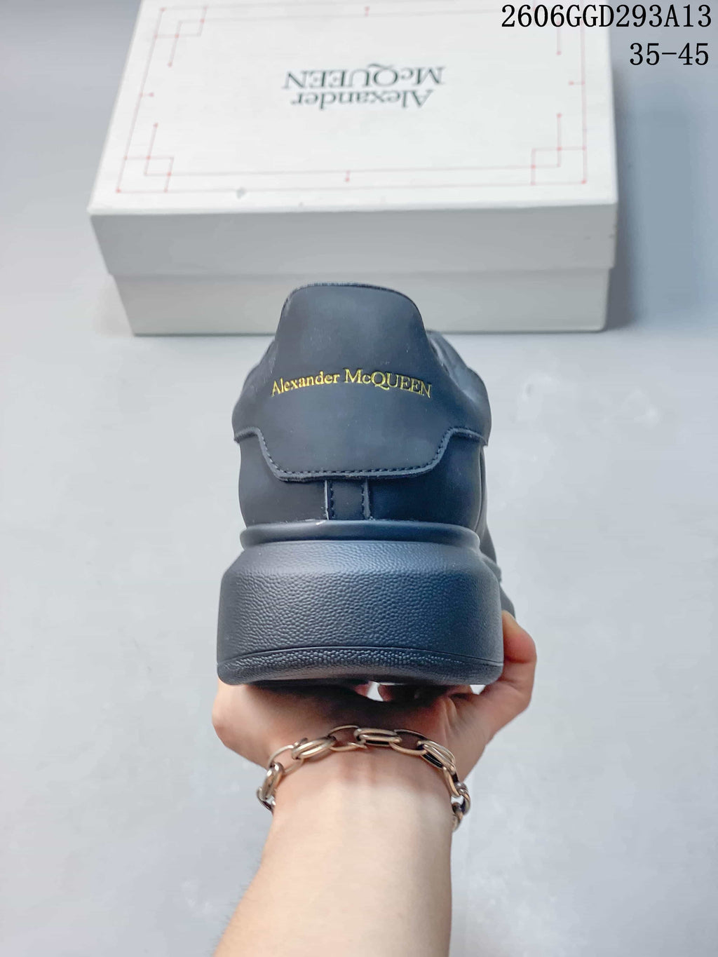 Rear view of a dark charcoal sneaker with Alexander McQueen lettering on the heel.