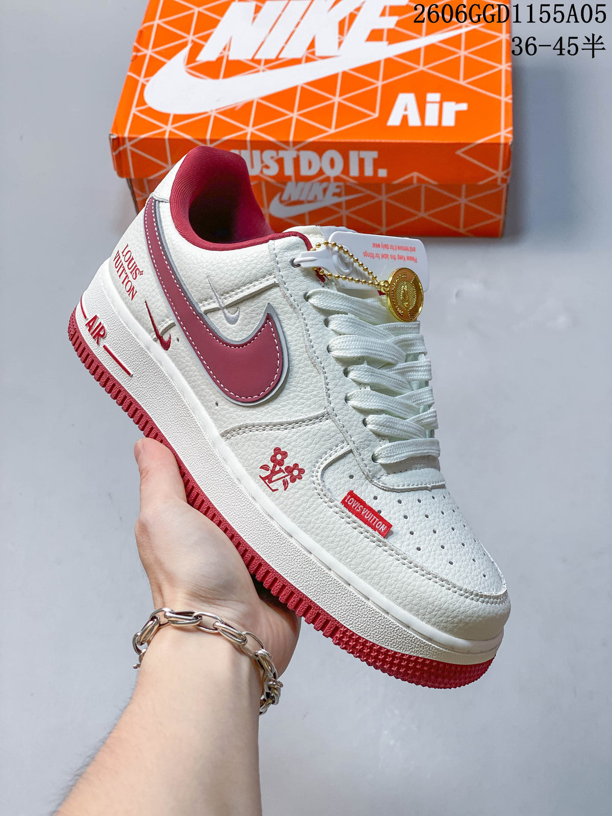 White low-top sneaker with burgundy accents and a decorative hanging tag