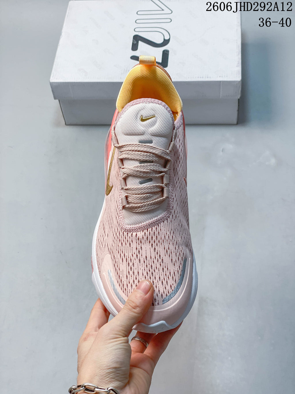 Top view of a pale pink Nike Air Max 270 shoe with yellow lining and gold-tone accents