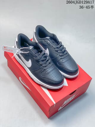 Pair of dark navy or black low-top Nike sneakers with white Swoosh accents on a red Nike shoe box.
