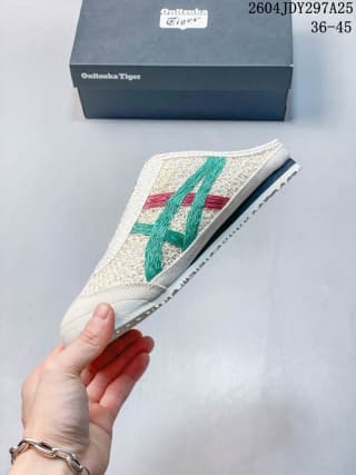 Side profile of the cream sneaker with green, red, and navy side detailing and a low-profile sole.