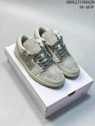 Pair of gray and green Air Jordan 1 Low sneakers displayed on a shoe box.